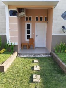 大松巴哇Bis homestay的草上有一扇门和一把椅子的房子