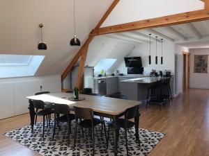 皮利尼蒙特拉谢Le Loft Deveney-Mars的厨房以及带木桌和椅子的用餐室。