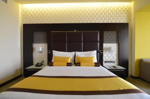 迪拜色调精品酒店的一间卧室配有一张带黄色枕头的大床