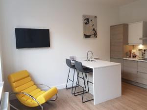 切斯特34 Cuppin Street - luxury city centre apartment!的厨房配有桌椅和水槽。