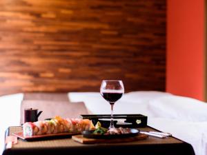 金泽金泽艾特苏士餐厅和旅馆的一张桌子,上面放着一杯葡萄酒和一盘食物