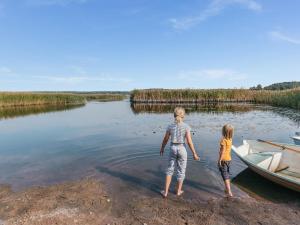 波尔沃Holiday Home B by Interhome的两个孩子站在湖岸边,坐了船