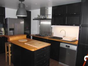 勒帕莱La Saline的厨房配有黑色橱柜和木制台面