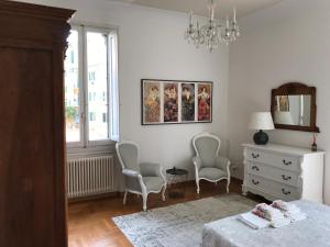 佛罗伦萨Romantic and Charming Apartments的一间卧室配有两把椅子、一张床和一个梳妆台