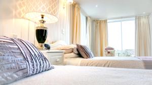卡莱尔贝斯顿乡村旅馆的一间卧室设有两张床、一盏灯和一扇窗户。