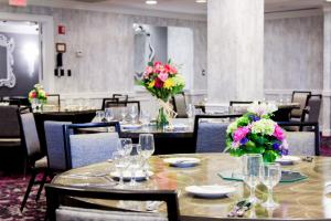 华盛顿The Churchill Hotel Near Embassy Row的用餐室配有桌椅和鲜花