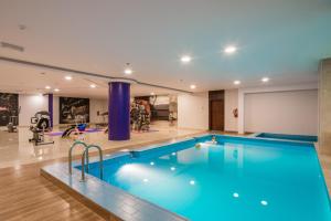阿尔阿尔Le Park Concord Hotel的大型客房的大型游泳池,设有健身房