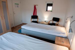 图什比STF Valbergsängen Sporthotell的客房设有两张床、一张桌子和两把椅子。