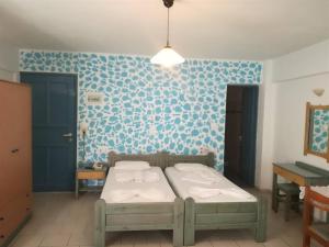 赫索尼索斯Olympic Star的一间卧室设有一张床和蓝色的墙壁