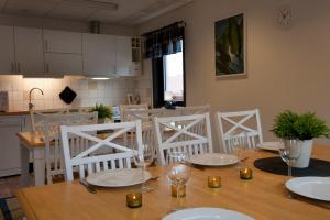 图什比STF Valbergsängen Sporthotell的餐桌、白色椅子和厨房