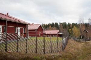 图什比STF Valbergsängen Sporthotell的红房子前面的围栏