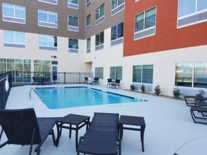 卡罗尔顿Holiday Inn Express & Suites - Carrollton West, an IHG Hotel的一座带桌椅的游泳池