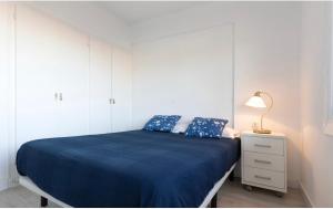 卡拉费尔Calafell playa lateral mar的白色卧室配有蓝色的床和灯