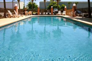 比洛克西比洛克西-海滩大道假日酒店的一个带桌椅的大型蓝色游泳池