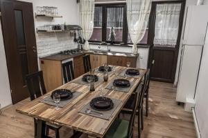 锡纳亚Elatos Luxury Villas Erato的厨房配有木桌和盘子