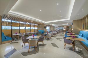 Yaoqiao郑州龙子湖智选假日酒店的一间带桌椅和蓝色家具的餐厅