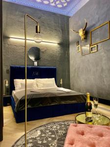 布达佩斯Noble Boutique Hotel - Adults Only的一间卧室配有一张床和一张桌子及一瓶葡萄酒