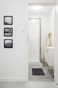华沙CRISTINE APARTMENT的白色的浴室设有通往淋浴的门