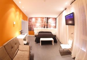 圣比森特德拉松谢拉松斯厄拉别墅酒店的一间卧室配有一张床、一台电视和一张沙发