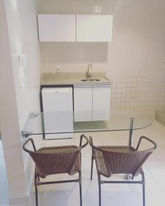 卡达斯诺瓦斯HOT SPRINGS HOTEL Caldas Novas-FLAT VIP的厨房配有玻璃桌和两把椅子