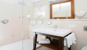 巴特格勒嫩巴赫allgäu resort的白色的浴室设有水槽和淋浴。