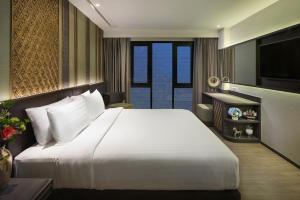 曼谷Chillax Heritage Hotel Khaosan的卧室配有一张白色大床和电视。