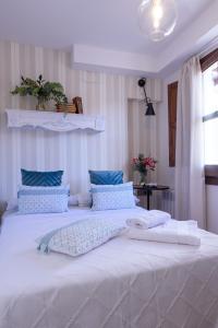 格拉纳达Häxaris Casa Boutique by Florentia Homes的卧室内的一张带蓝色枕头的大型白色床