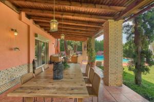 苏尼翁Villa Casa Del Sol with private pool的一个带屋顶的庭院里的一张木桌子和椅子
