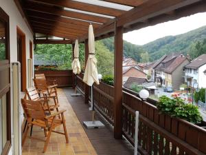 哈茨山区黑尔茨贝格Haus Am Waldesrand的阳台配有椅子和遮阳伞,俯瞰着城镇