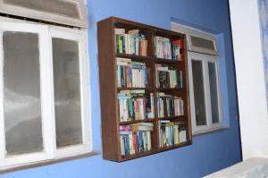坎多林Libton Manor的书架上装满书的书架,放在带窗户的房间