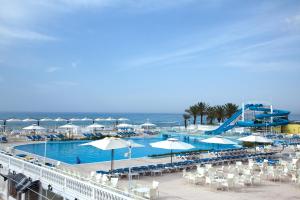 哈马马特Samira Club Family and couples only的一个带椅子和遮阳伞的游泳池以及大海