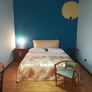 阿拉代奥Le Vallonee B&B的蓝色卧室,配有床和椅子