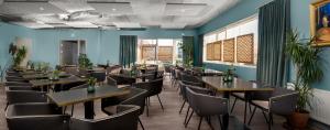 雷克雅未克ODDSSON Hotel的一间设有桌椅的餐厅,位于拥有蓝色墙壁的房间