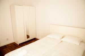 罗兹Apartament Blu的白色卧室配有床和镜子