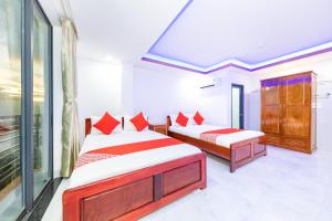 芽庄Q3 Viet An Hotel Nha Trang的一间卧室设有两张床和窗户。