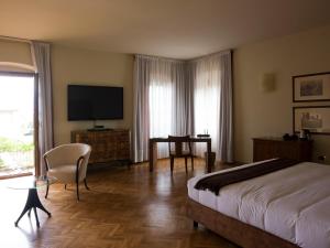 科尔特弗兰卡黎莱斯佛兰切柯尔塔酒店的一间卧室配有一张床、一张书桌和一台电视