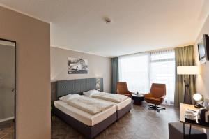 斯图加特Arthotel ANA Neotel的配有一张床和一张书桌的酒店客房