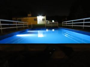 科尔多瓦Cabañas Luz de Luna, Comuna San Roque-Punilla的一座晚上点亮的大型游泳池
