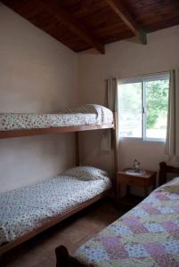 科尔多瓦Cabañas Luz de Luna, Comuna San Roque-Punilla的一间卧室设有两张双层床和一扇窗户。