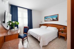 里沃利里沃利酒店的酒店客房配有一张床、一张书桌和一台电视。
