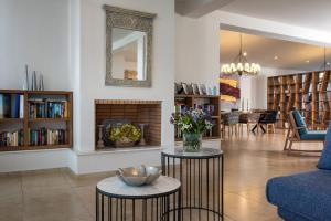 瓦西里亚斯Kassandra Bay Resort, Suites & Spa的客厅设有2张桌子和壁炉
