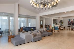 瓦西里亚斯Kassandra Bay Resort, Suites & Spa的带沙发和吊灯的大型客厅