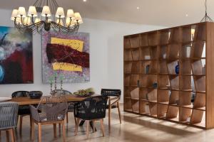 瓦西里亚斯Kassandra Bay Resort, Suites & Spa的一间带木桌和椅子的用餐室