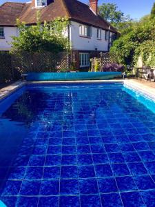 HookwoodHazelwick的一座位于房子前方的蓝色瓷砖游泳池