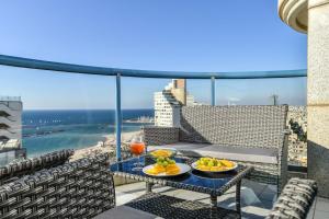特拉维夫Picturesque 3BR Apt w Balcony & Parking Near Beach by Sea N' Rent的阳台上桌子上的托盘食物