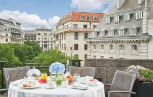 伦敦奥德维奇一号酒店的带有白色桌布的桌子,位于带建筑的阳台