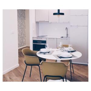 庞特维德拉Casas Á Beira - Apartamentos的白色的厨房配有白色的桌子和椅子