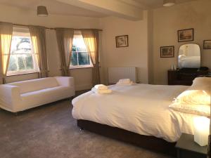 勒德洛Caynham Court的卧室配有一张白色的大床和一张沙发。
