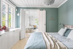斯德哥尔摩Peaceful, Picturesque Lake & Forest Retreat的一间带蓝色墙壁的卧室、一张床和一间餐厅