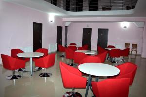 库塔伊西Hotel Okriba的一间摆放着桌子和红色椅子的房间